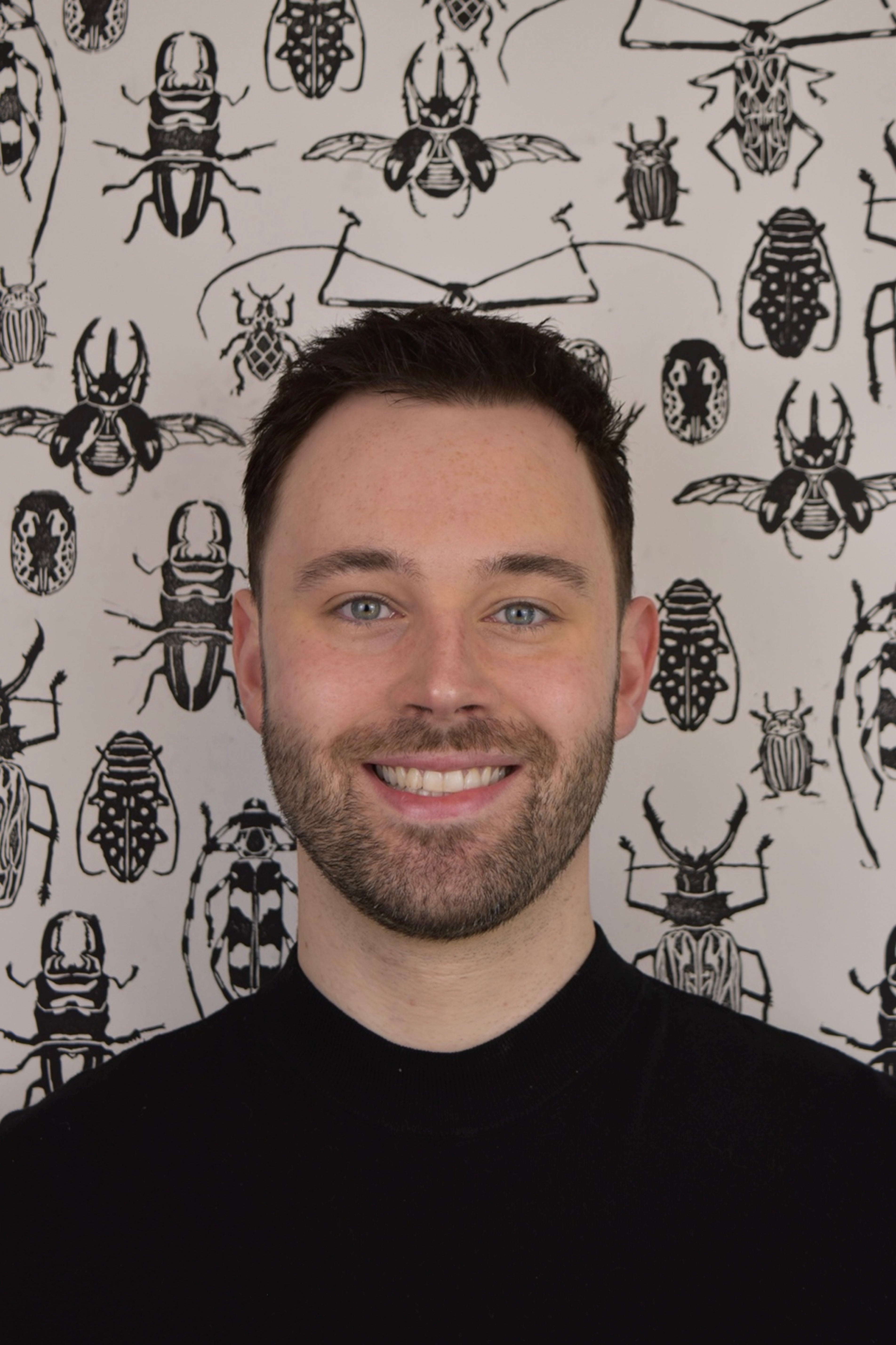 Handsome Artist in front of printed beetle backdrop